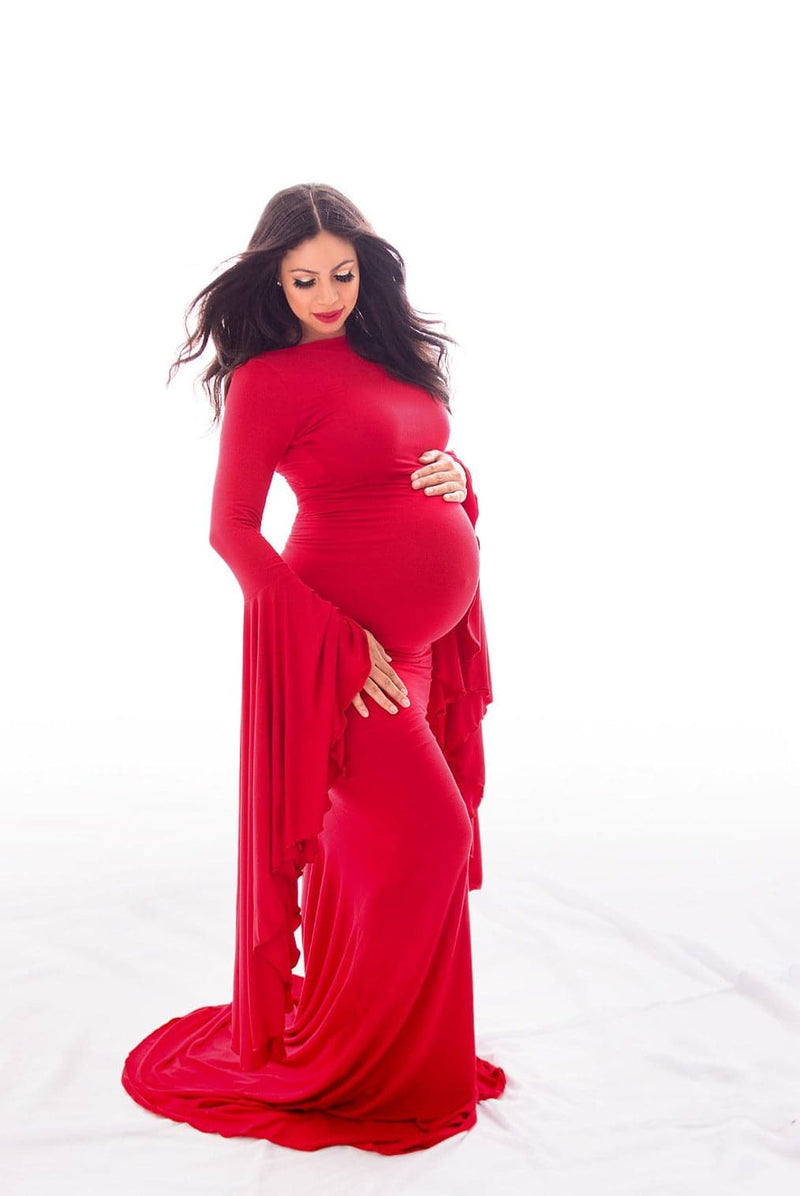 Beautiful expecting mother in red Sew Trendy Marisol gown standing in white backlit studio. Photo by Belly Beautiful Portraits.
