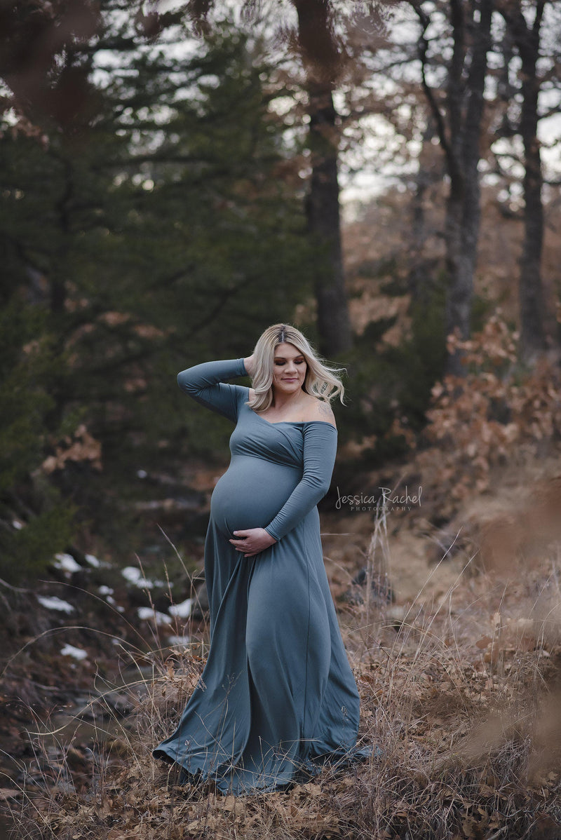 Pregnant woman wearing the Bree gown in Frosted Evergreen by Sew Trendy standing on forest path.