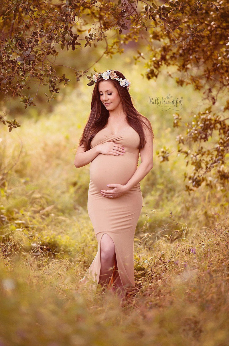 Expecting mother wearing the Courtney gown in camel standing in tree grove