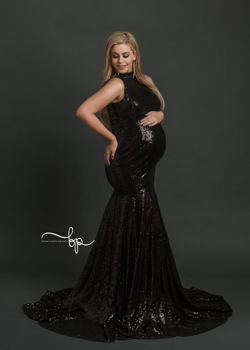 Pregnant woman wearing the allesandra gown in black sequins by Sew Trendy standing on grey backdrop