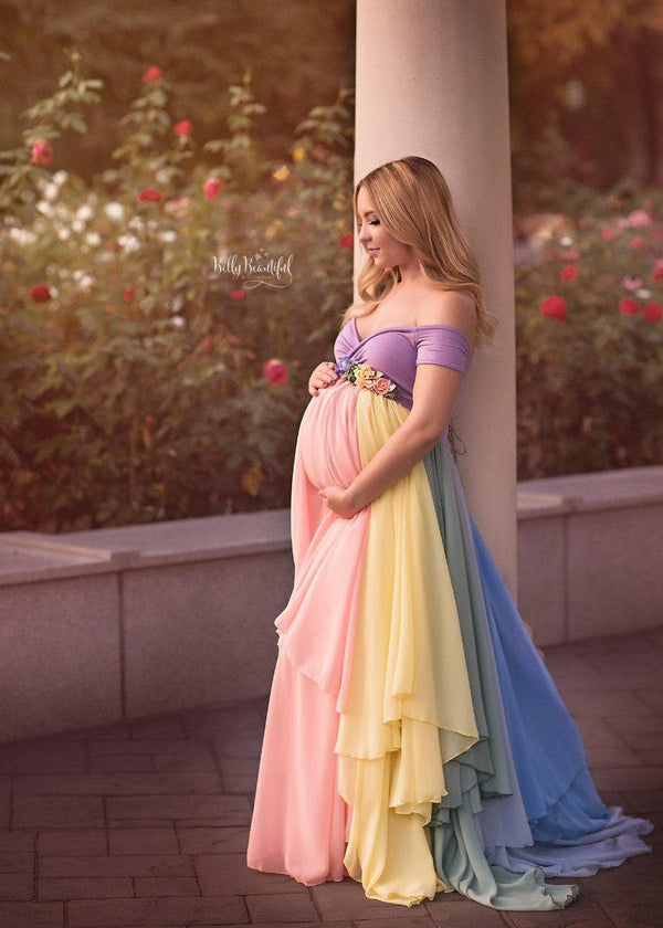 Pregnant mother wearing the Hope Gown in Pastel Tones by Sew Trendy Accessories with flowers in the background.