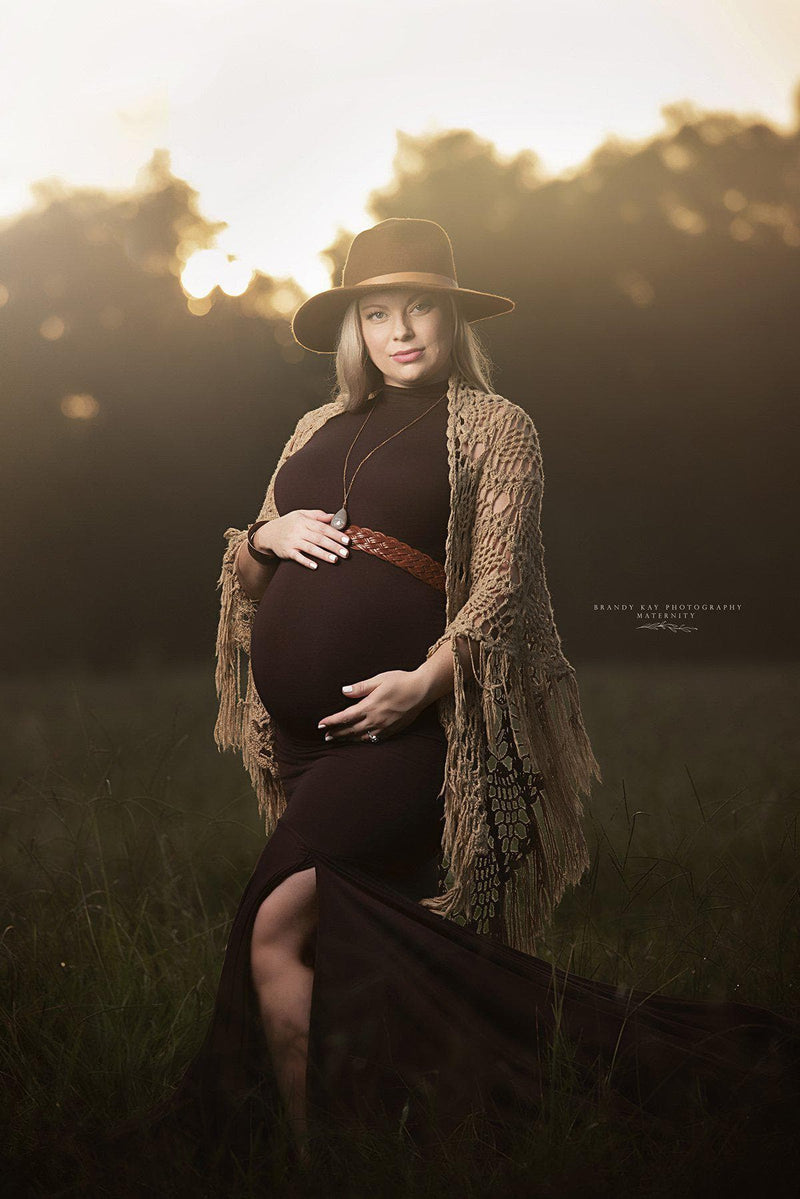 Pregnant woman wearing the Allesandra gown by Sew Trendy standing in field with golden light
