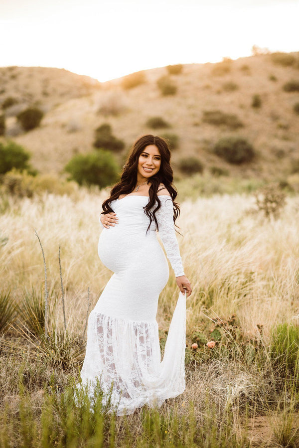 Pregnant woman in the Priscilla Gown in White by Sew Trendy Accessories standing in a golden field.