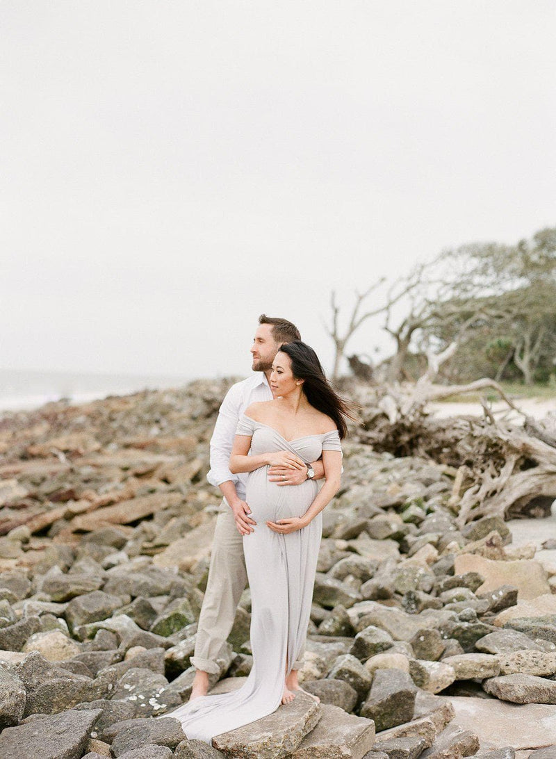 Pregnant Mother in the Kiara gown by Sew Trendy Accessories in grey at the beach.