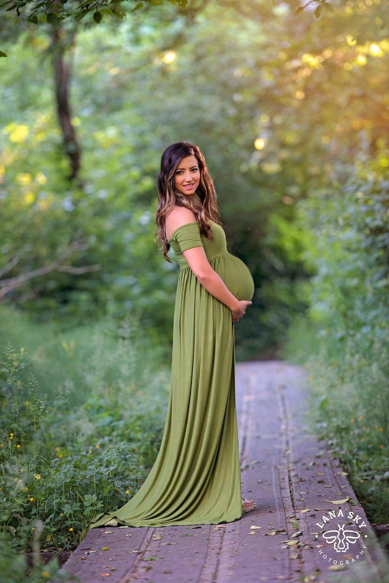 Pregnant mother in the Kelly Gown by Sew Trendy Accessories in moss on a bridge.