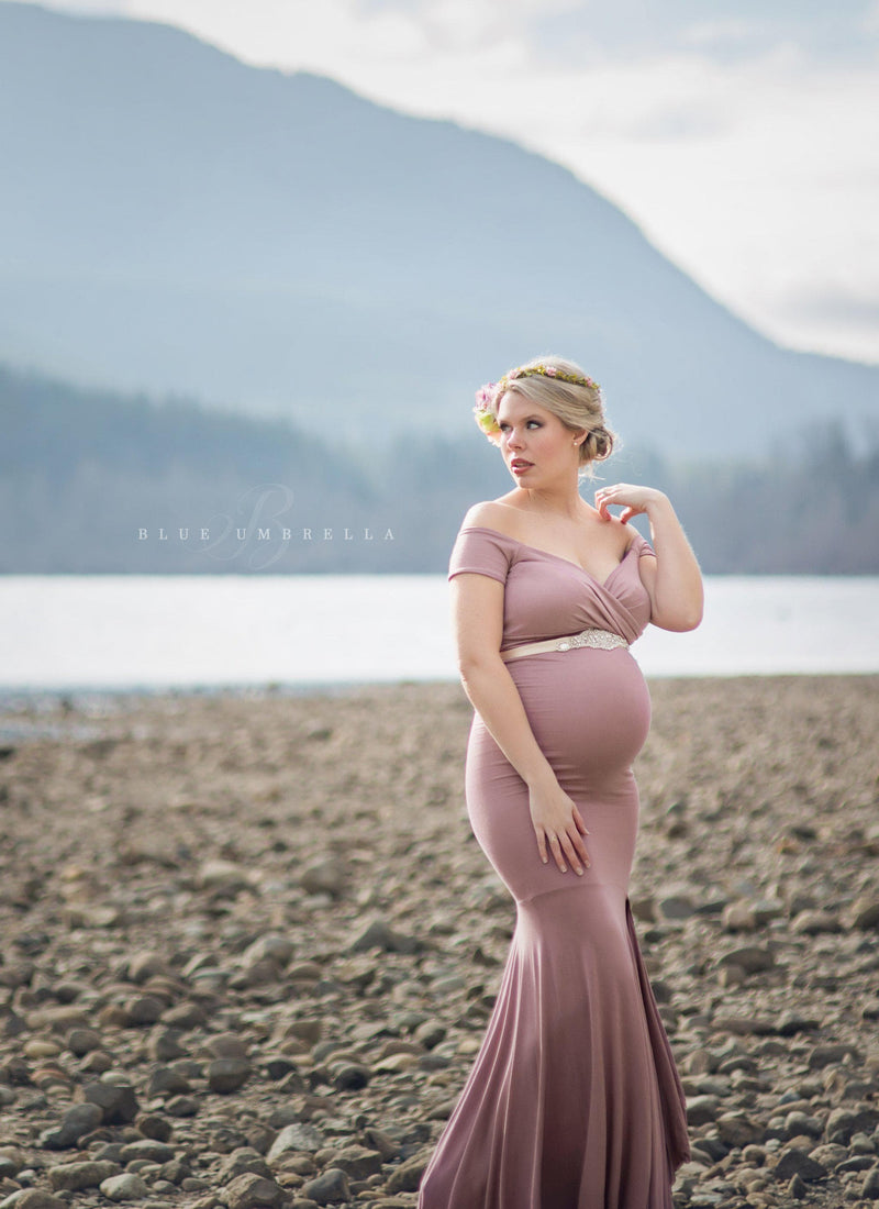 Beautiful expecting mother wearing the Allysa gown in mauve by Sew Trendy standing next to lake in winter.