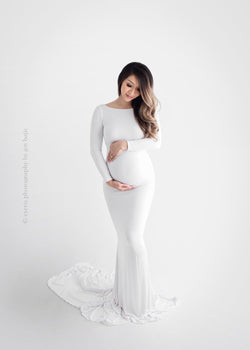 Pregnant mother in the Krysten Gown by Sew Trendy Accessories in White in a studio with a white background.