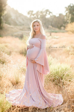 Expecting mother wearing the Gwen gown in mauve by Sew Trendy standing in a field at golden hour
