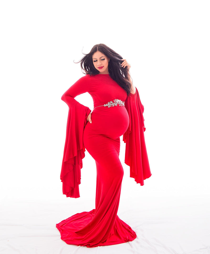 Beautiful expecting mother in red Sew Trendy Marisol gown standing in white backlit studio. Photo by Belly Beautiful Portraits.