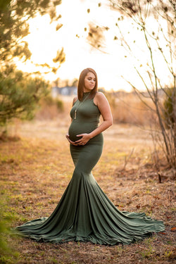 Pregnant woman in the Allesandra gown by Sew Trendy standing in a sunkissed field