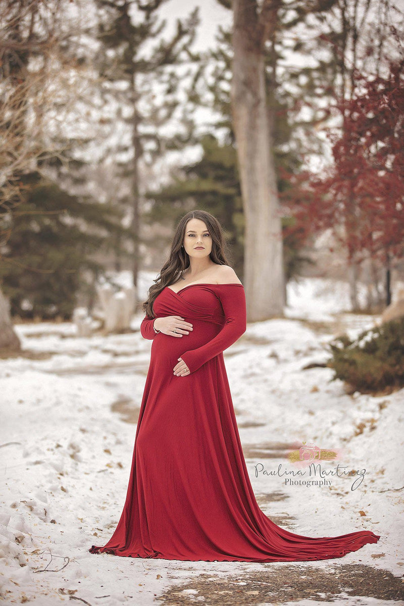 Pregnant woman wearing Bree gown in red by Sew Trendy standing on snowy path.