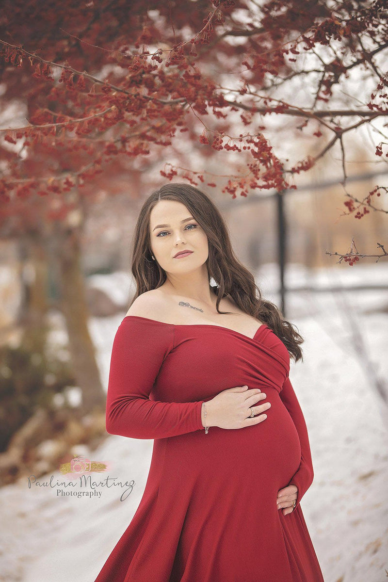 Pregnant woman wearing the Bree gown in red by Sew Trendy, standing on snowy path.
