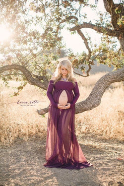 Pregnant woman in the Roxy Gown in Plum by Sew Trendy Accessories standing in a golden field with trees.