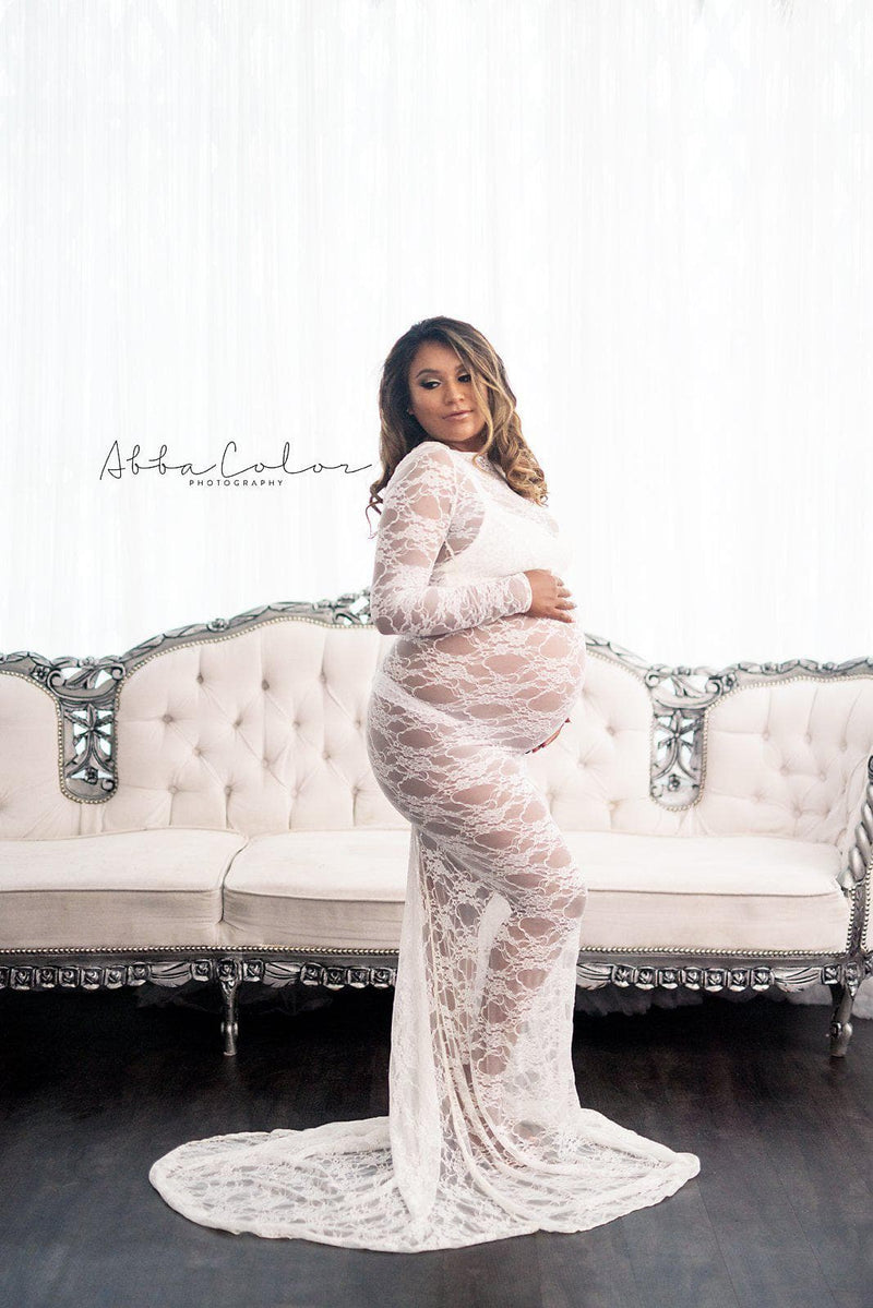 Pregnant woman in the Phoebe Gown in Ivory by Sew Trendy Accessories in studio with a white background and vintage couch.