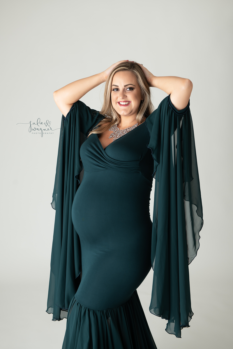 Beautiful pregnant woman wearing the Allura gown in Blue Spruce by Sew Trendy
