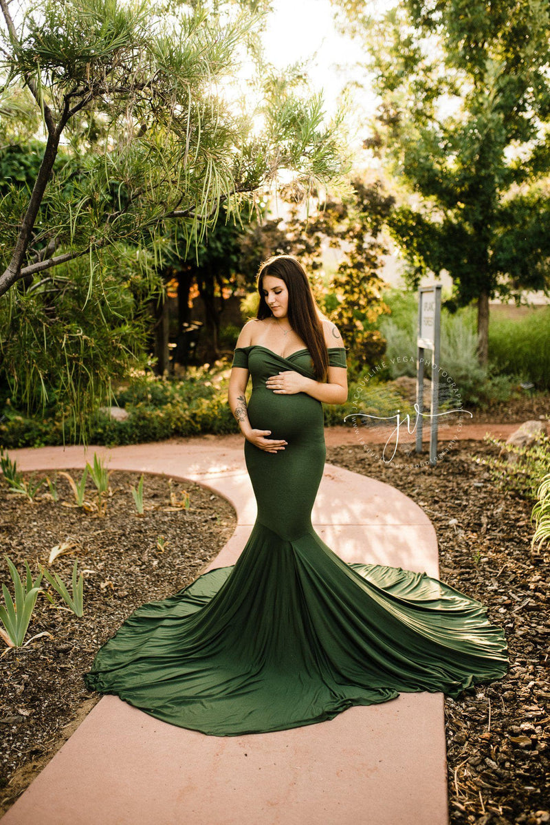 Beautiful expecting mother wearing the allysa gown in evergreen by Sew Trendy standing on path in later summer.