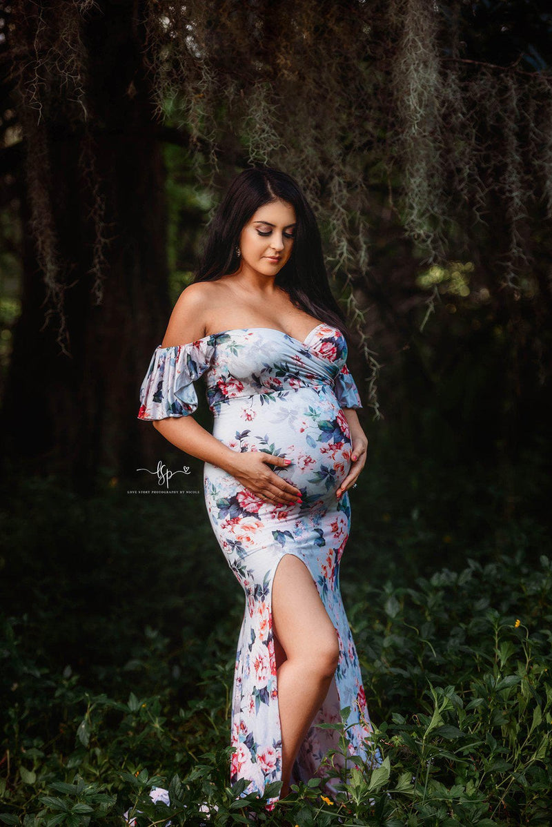 Expecting mother wearing the Arianna gown in grey floral print by Sew Trendy standing by willow tree.