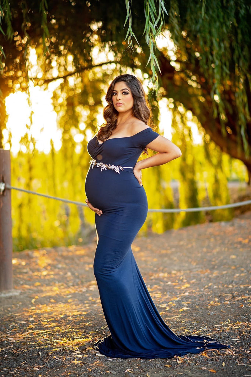 Expecting mother wearing the Audrey gown by Sew Trendy standing under willow tree.