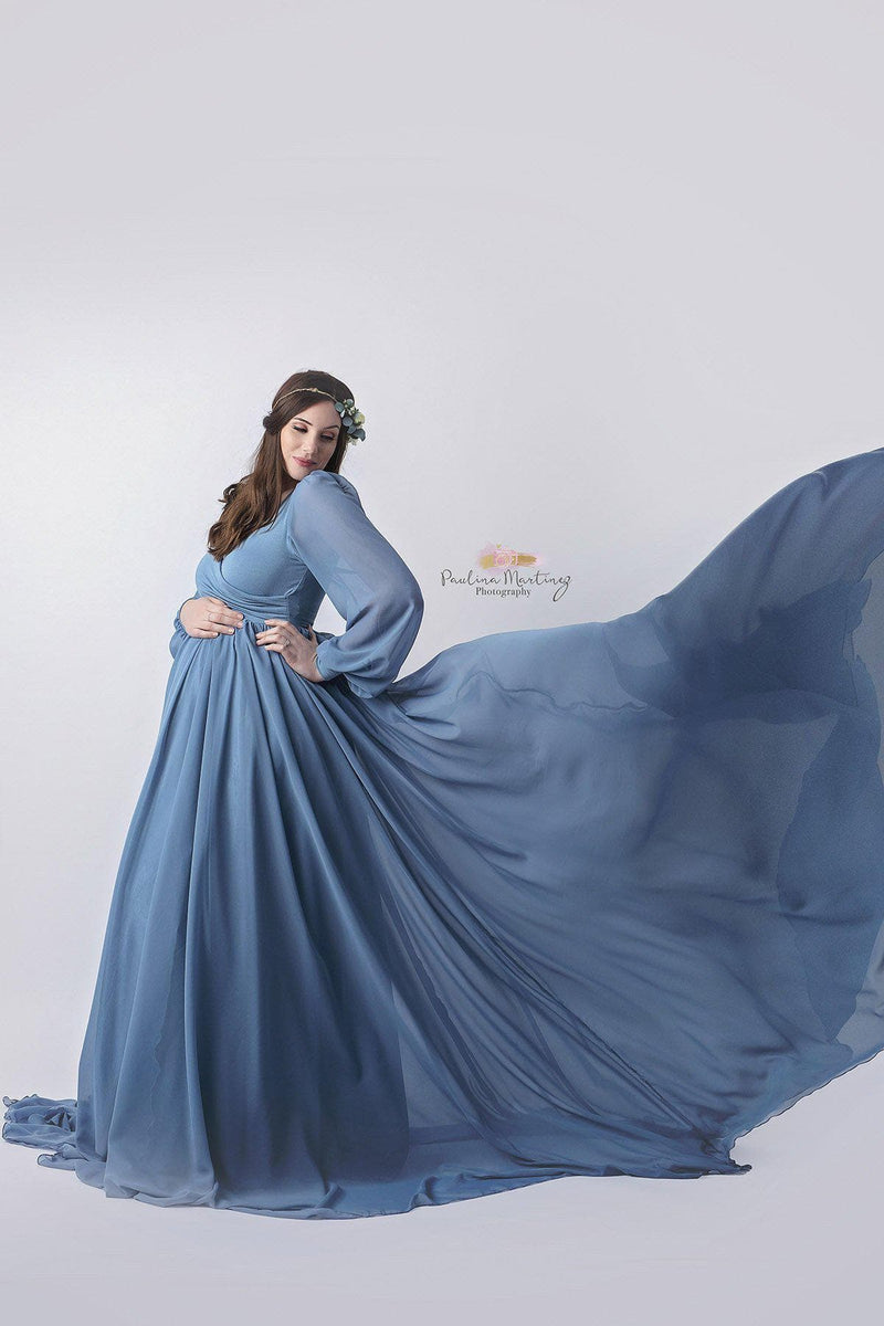 Pregnant mother wearing Brigitte gown in steel blue by Sew Trendy standing in studio on white background