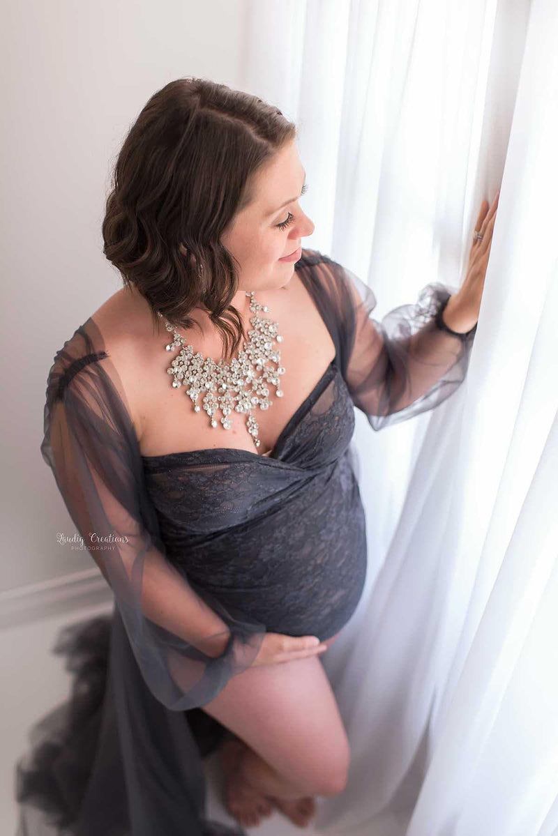 Expecting mother wearing the Chante gown and Libby bodysuit by Sew Trendy standing in backlit studio