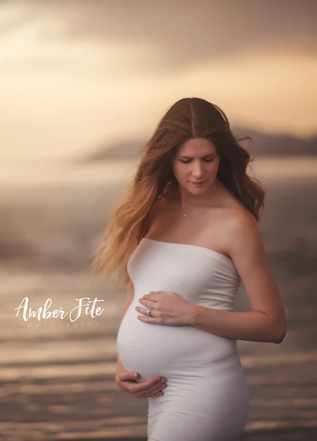 Pregnant woman wearing the Teagan fitted slip by Sew Trendy standing on beach at sunset