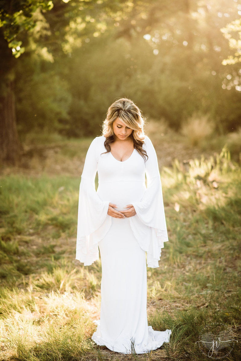 Pregnant mother wearing Veda gown in ivory by Sew Trendy standing in sunkissed tree grove