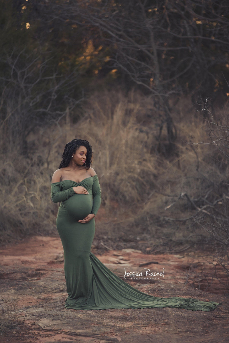Pregnant woman wearing the Emerlie gown in evergreen by Sew Trendy standing in field during autumn