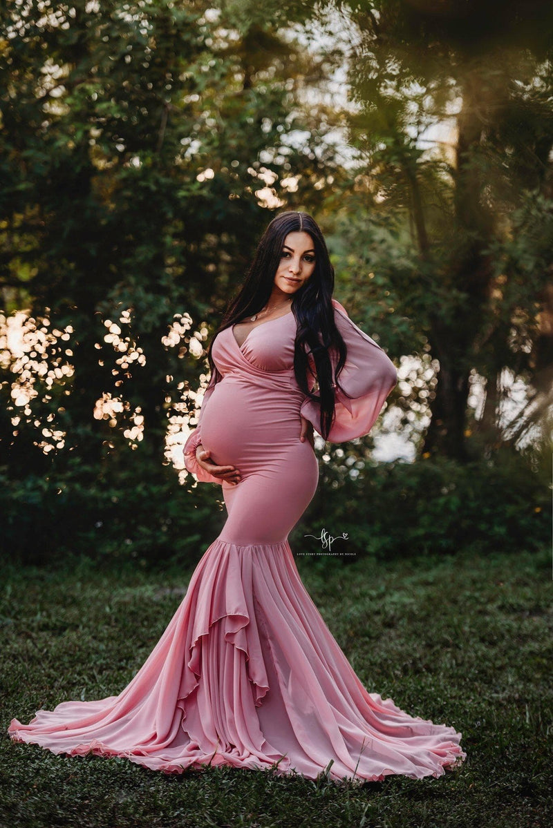 Pregnant mother wearing the Francis gown in antique rose by Sew Trendy standing in aa grove of trees