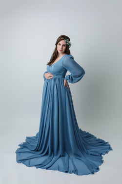 Pregnant mother wearing Brigitte gown in steel blue by Sew Trendy standing in studio on white background