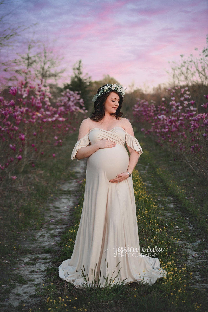 Expecting mother wearing the aspen gown in champagne by Sew Trendy standing in cherry blossom field.