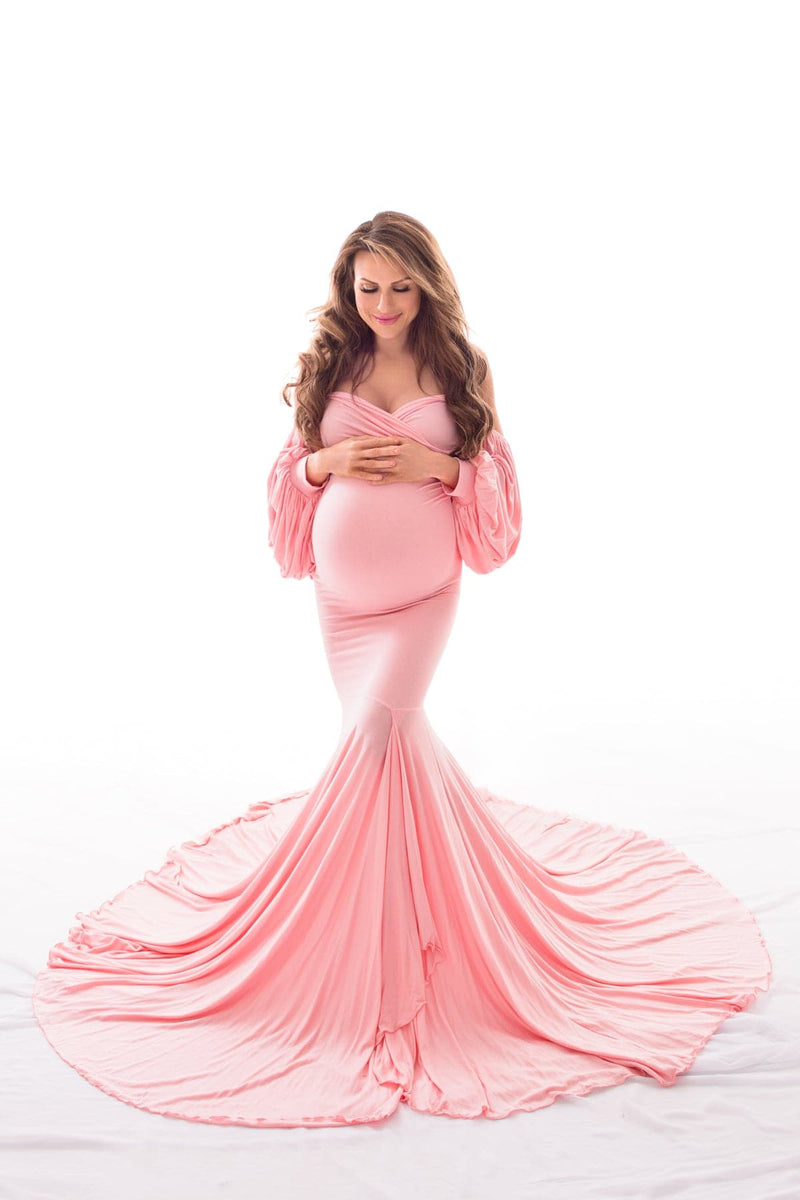 Glowing pregnant woman wearing the Erica gown in dusty pink by Sew Trendy Accessories in a backlit studio.