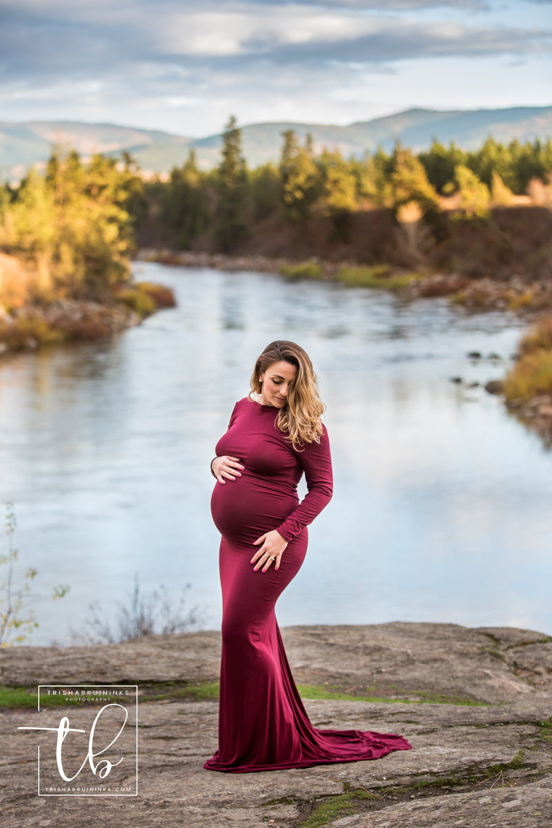 Pregnant mother in the Krysten Gown in burgundy by Sew Trendy Accessories near a river