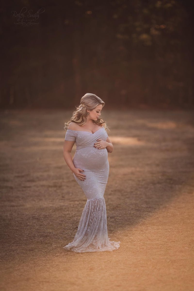 Pregnant woman wearing the bella gown in grey by Sew Trendy standing in sunkissed field.