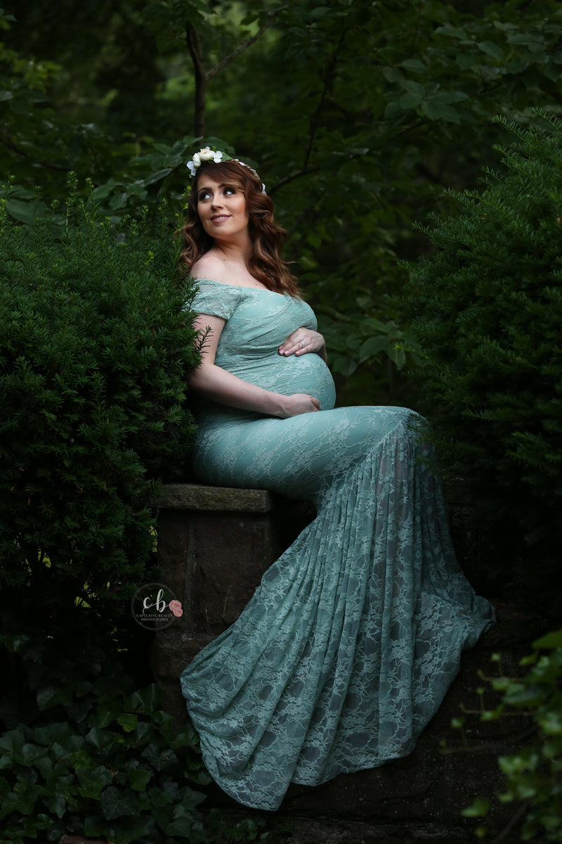 Pregnant woman wearing the bella gown in sage by Sew Trendy sitting in forrest.
