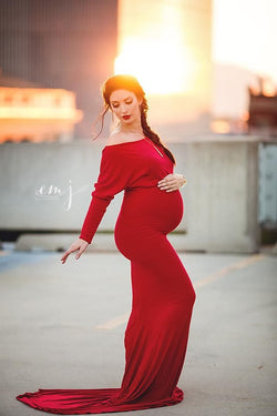 Pregnant mother in the Jaden Gown in Red by Sew Trendy Accessories on a rooftop during sunset.
