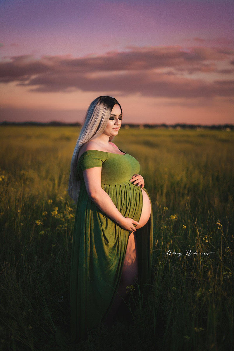 Pregnant mother in the Kelly Gown by Sew Trendy Accessories in Moss in a field with tall grass.