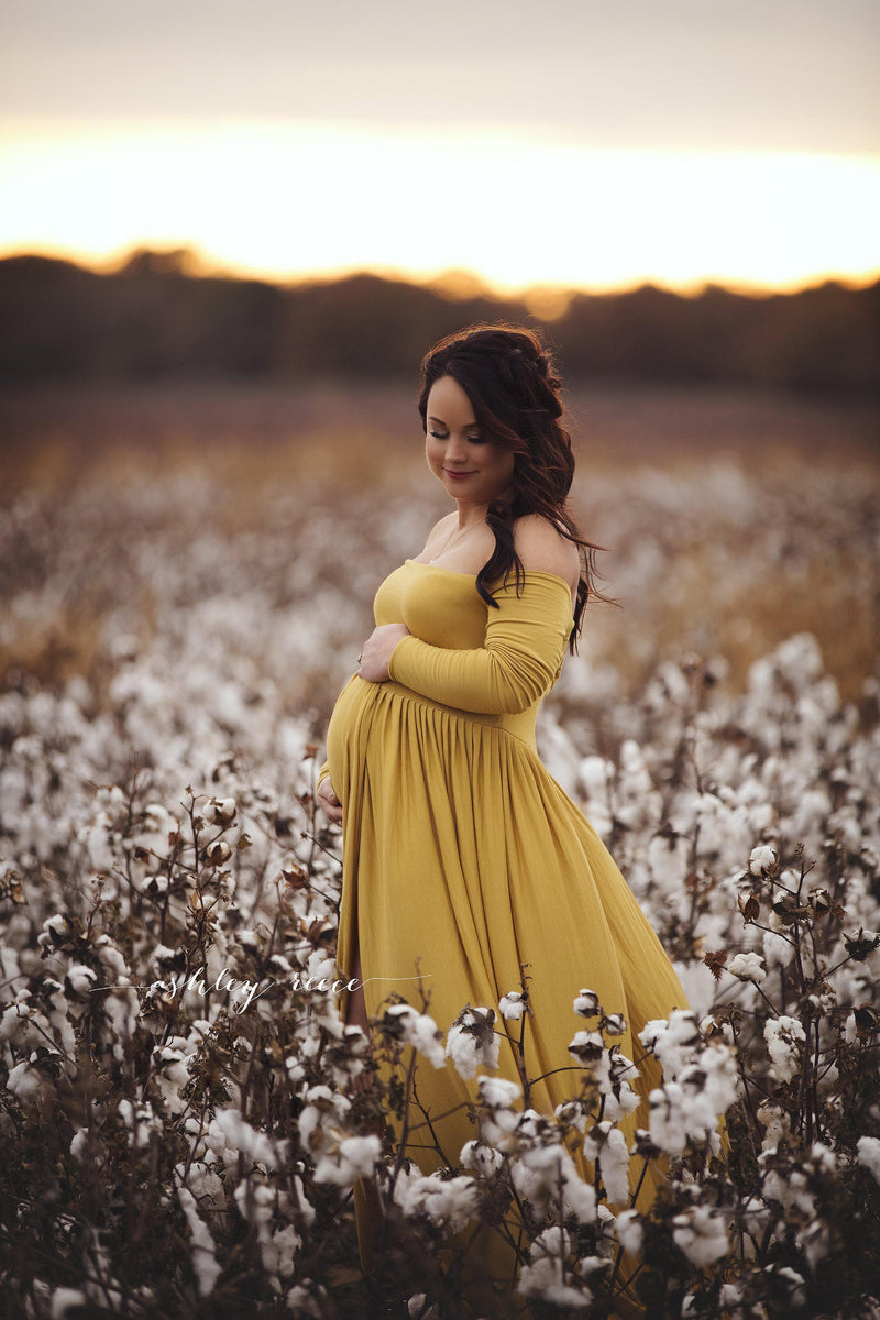 Pregnant woman in the Miriam Gown in Gold by Sew Trendy Accessories standing in a cotton field.