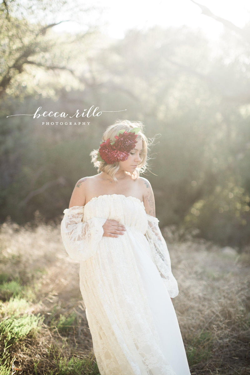 Expecting mother wearing the Valerie gown in ivory by Sew Trendy standing in field at golden hour